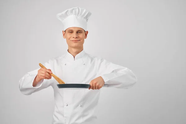 Allegro chef maschio con una padella nelle mani lavoro di cottura — Foto Stock