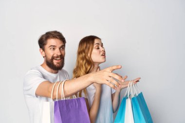 Ellerinde paketler, alışveriş eğlencesi olan genç bir çift.