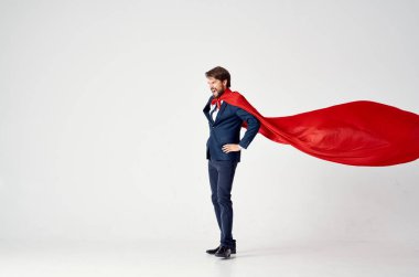 Süper kahraman kıyafeti giymiş kırmızı pelerinli bir adam güç koruması.