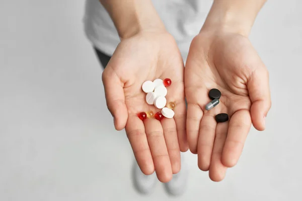 Sick woman pills in hand pain reliever light background — Stock Photo, Image