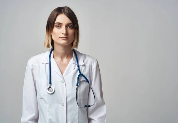 Kadın doktor steteskop iyileştirme prosedürleri hafif arka plan — Stok fotoğraf