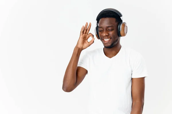 Hombre en auriculares pro Camisetas blancas tecnología Amante de la música fondo claro — Foto de Stock