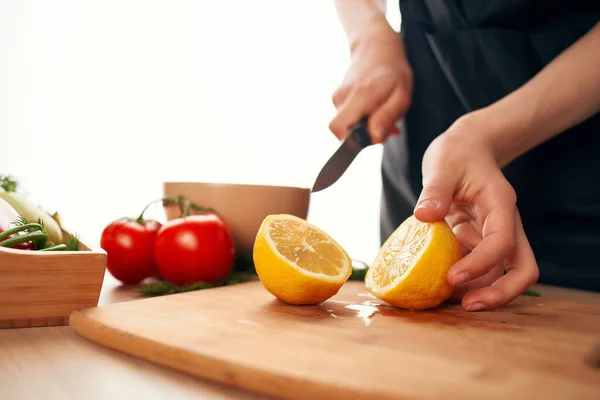Affettare limone sul bordo con un coltello cucina ingredienti di cottura — Foto Stock