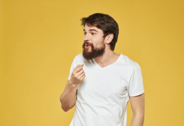 Beyaz tişörtlü duygusal adam hoşnutsuz görünüyor.