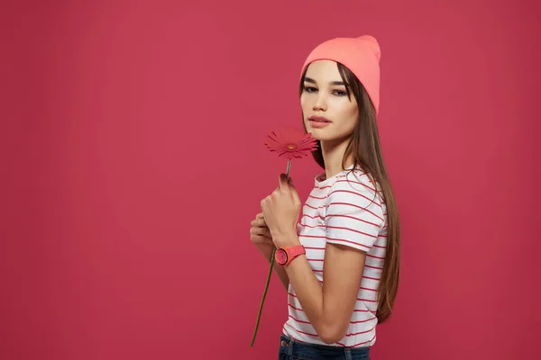 Morena vestindo um chapéu rosa vermelho flor maquiagem decoração rosa fundo — Fotografia de Stock