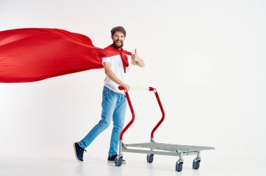 Kırmızı pelerinli sakallı adam izole edilmiş bir kutuda naklediliyor.