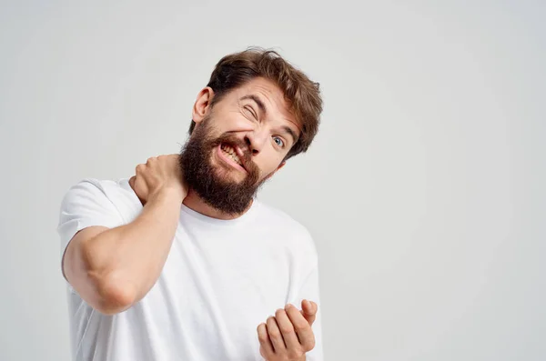 하얀 티셔츠를 입은 남자는 목에 통증을 호소하는 약을 복용하고 있다. — 스톡 사진