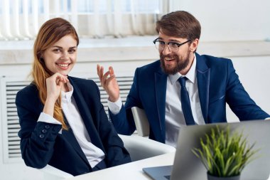 İş adamı ve kadın laptopun önünde konuşuyor.