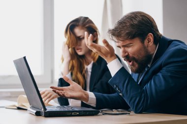 İşadamı ve kadın ofiste dizüstü bilgisayarın önünde profesyonellerin önünde.