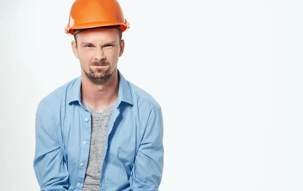 Homem em uma camisa azul emoções fundo luz profissional — Fotografia de Stock