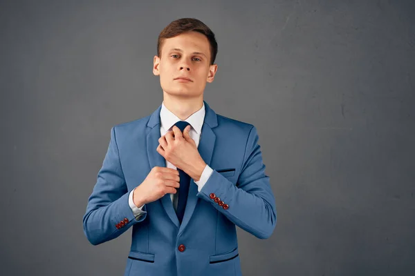 Бизнесмен в костюме выпрямляет галстук в офисе — стоковое фото