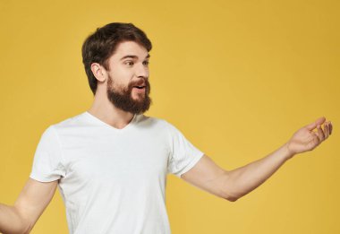 duygusal sakallı beyaz tişörtlü adam sarı arka plan