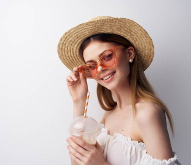 Güzel bayan pipet ışıklı arka planda içki içer.