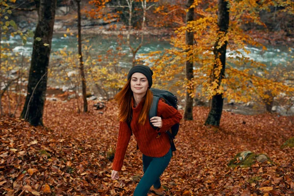 Sırt çantalı bir kadın sonbahar ormanında seyahat ediyor. — Stok fotoğraf