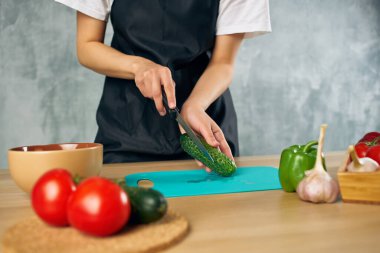 Siyah önlüklü kadın evde vejetaryen salata diyeti yapıyor.