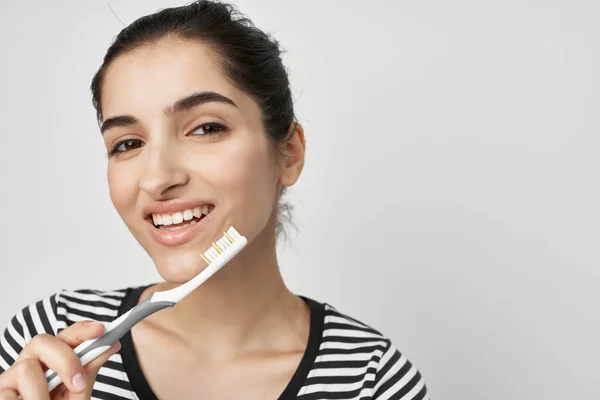 Mulher em uma escova de dentes de t-shirt listrada na mão isolado fundo — Fotografia de Stock