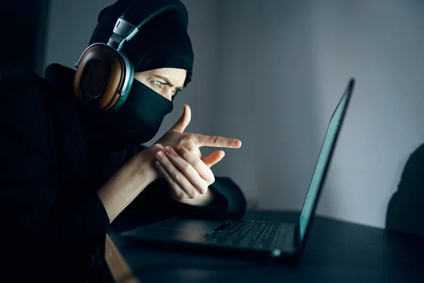 Mujer con máscara delante de la piratería de auriculares portátiles — Foto de Stock