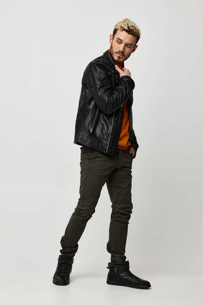 Muž v kalhotách a botách kožená bunda oranžový svetr trend sezóny — Stock fotografie