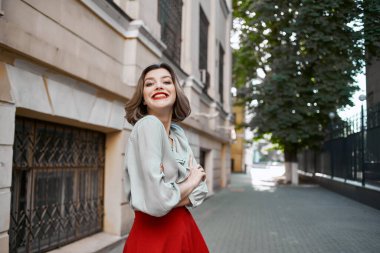 Caddedeki neşeli sarışın. Binanın yanında. Duygusallık var.