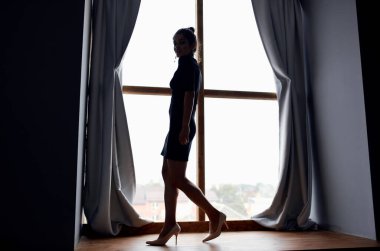 Siyah elbiseli ve poz veren bir kadın.