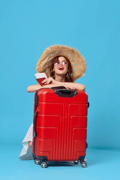 Kobieta z czerwoną walizką siedząca na podłodze paszport i bilety lotnicze styl życia — Zdjęcie stockowe