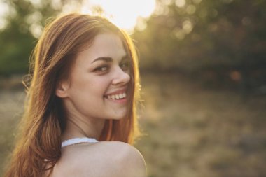 Beyaz elbiseli güzel bir kadın yaz aylarında temiz hava alıyor.