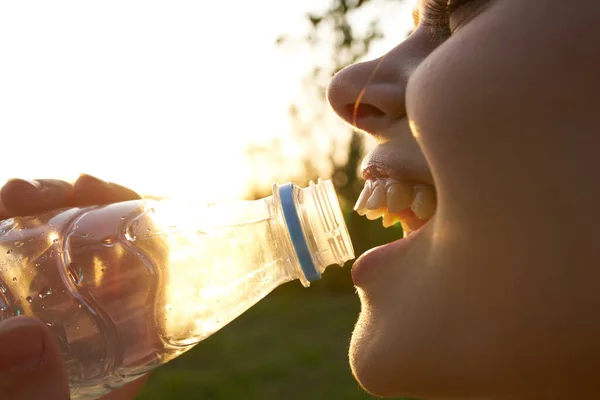 Vidám nő ivóvíz egy üveg és közelkép természet nyár — Stock Fotó