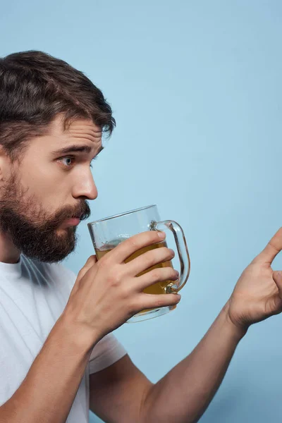 Szakállas férfi fehér póló sör bögre alkohol gyors élelmiszer kék háttér — Stock Fotó