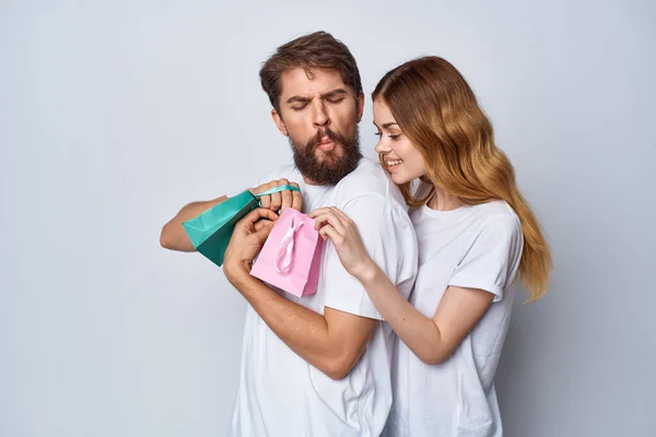 Hombres y mujeres emocionales en paquetes de camisetas con regalos fondo ligero de vacaciones — Foto de Stock