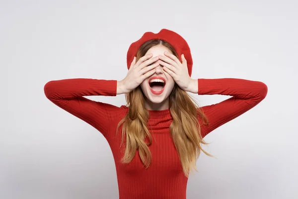 Schöne Frau mit einer roten Mütze auf dem Kopf Glamour hellen Hintergrund — Stockfoto