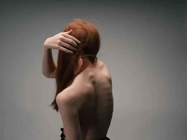 Γυναίκα με γυμνούς ώμους που θέτουν κόκκινα μαλλιά απομονωμένη φόντο — Φωτογραφία Αρχείου