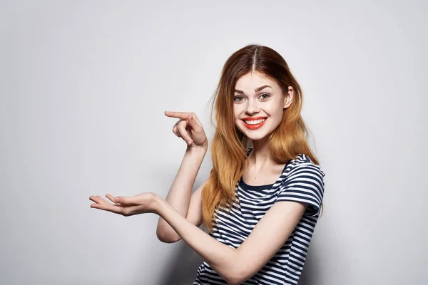 Bella donna in un gesto t-shirt a righe con le mani sfondo chiaro — Foto Stock