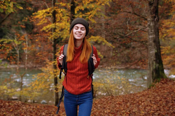 Kobieta z plecakiem podróży w jesiennym lesie — Zdjęcie stockowe