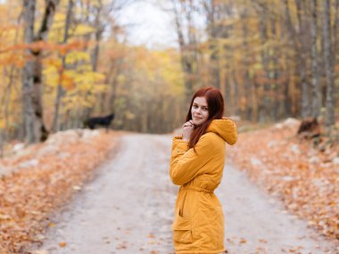 Doğada yürüyen kadın sonbahar ağaçları yol bulutlu hava