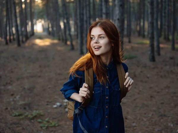 Χαρούμενη κοκκινομάλλα γυναίκα με σακίδιο στο δάσος ταξίδια — Φωτογραφία Αρχείου