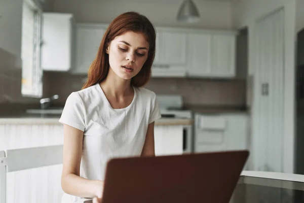 Mujer con portátil en la mesa freelancer trabajando fuera de la oficina habitación interior —  Fotos de Stock