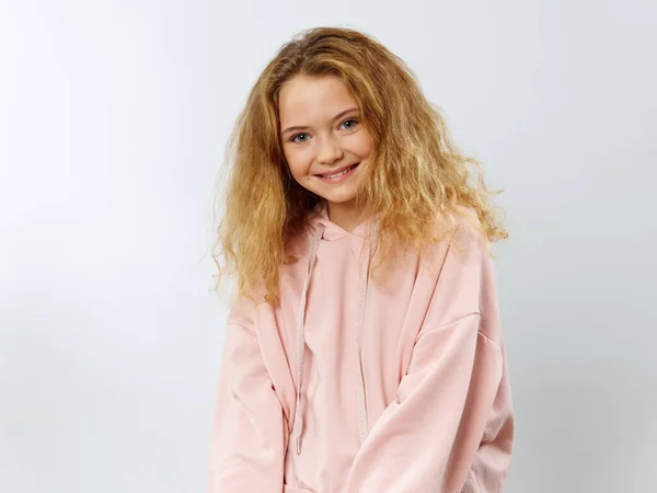 Happy girl in pink sweater on light background smiling cropped view — Stock Photo, Image