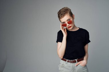 Kısa saçlı kadın el hareketi. Kırmızı dudaklar koyu arkaplan.