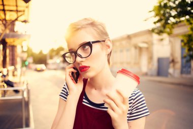 Güzel bir kadın yaz aylarında telefon konuşmaları yapıyor.