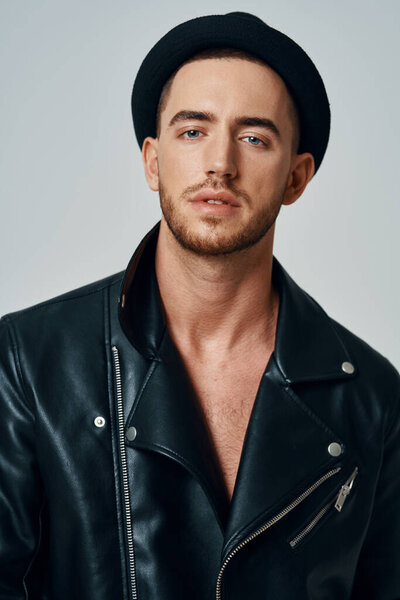 handsome man in leather jacket hat posing studio fashion