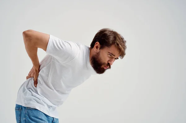 Emocional hombre en un blanco camiseta estrés medicina dolor de espalda estudio tratamiento — Foto de Stock
