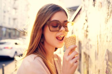 Çekici bir kadın dışarıda yürüyor dondurma yiyor, seyahat ediyor, eğleniyor.