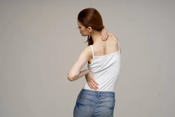 Kvinna i vit t-shirt smärta symtom i lederna artrit studio behandling — Stockfoto
