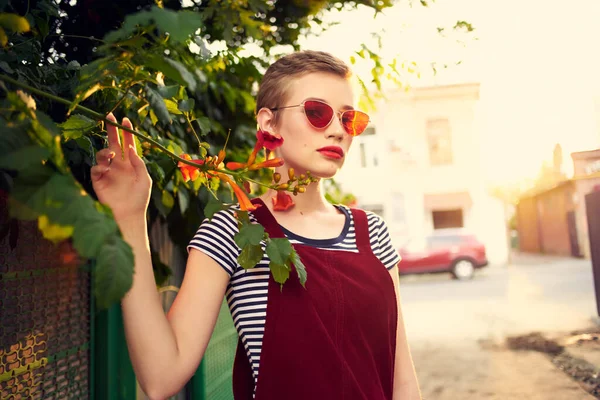 Bonita mujer usando gafas de sol al aire libre moda posando flores — Foto de Stock