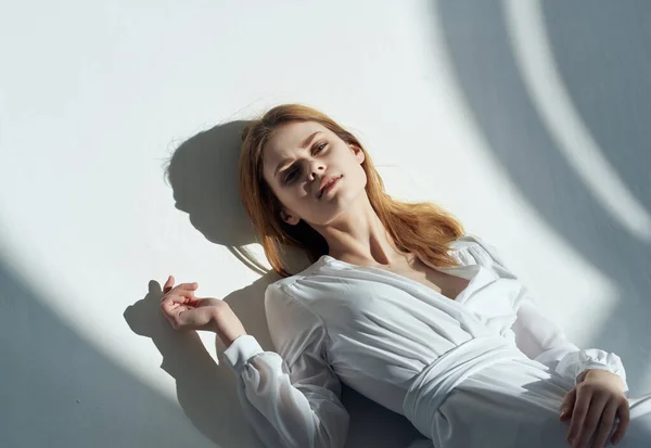Mulher bonita em vestido branco encontra-se no chão luz de fundo — Fotografia de Stock