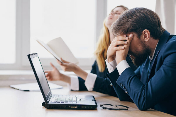 business man and woman sitting at a desk with a laptop communication professionals