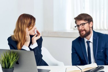 Erkek ve kadın yöneticiler dizüstü bilgisayar profesyonelleri teknolojisi önünde birlikte çalışırlar.