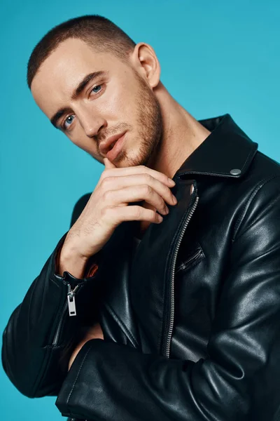 handsome man short haired leather jacket close-up blue background