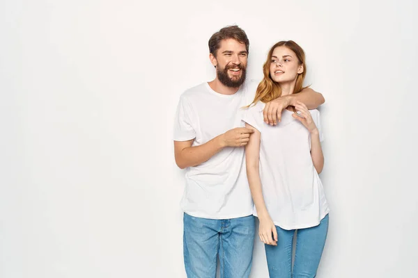 Мужчина и женщина в белых футболках стоят рядом с семейным светлым фоном — стоковое фото