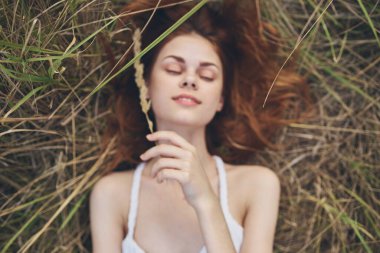 Neşeli kadın yaz tatilinde samanlıkta yatıyor.